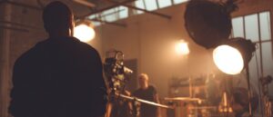 Gaffer works on a film set with lighting equipment and film crew during film production